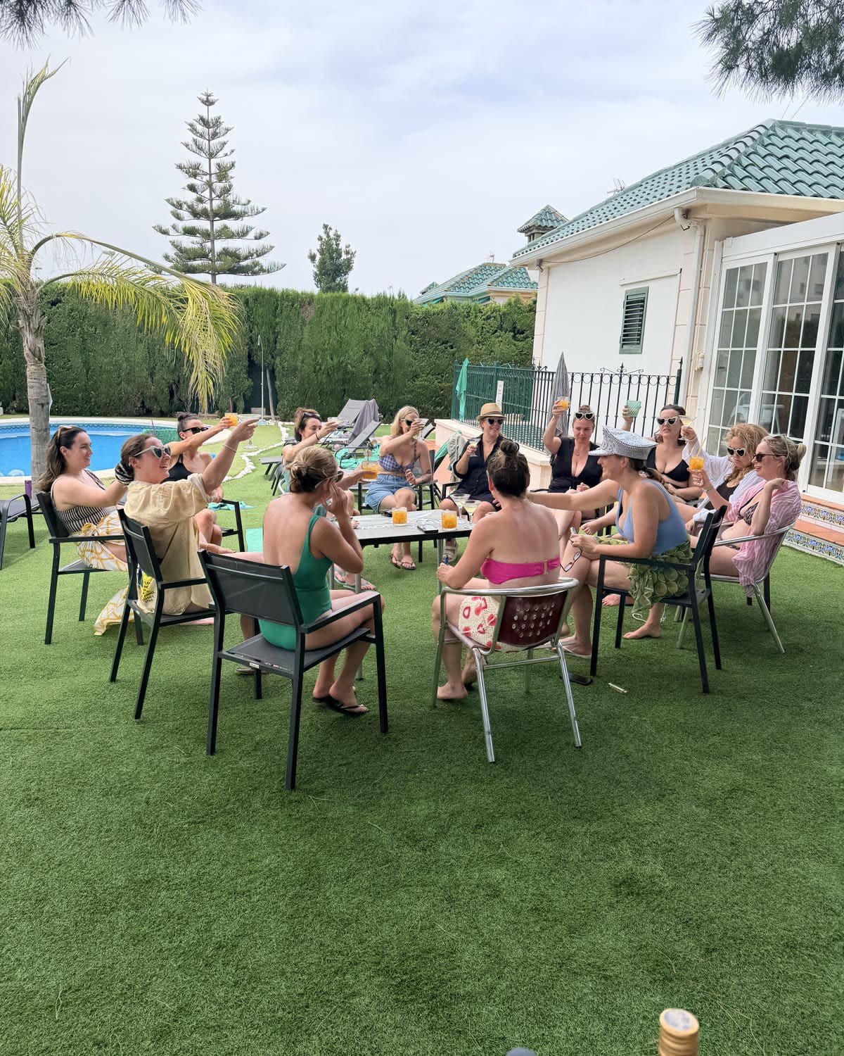 A real group enjoying drinks by their villa pool