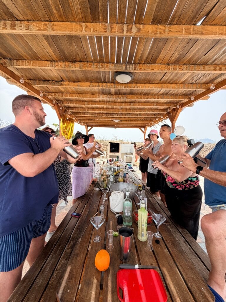 Family and friends shaking cocktails at a 40th birthday cocktail workshop in a villa